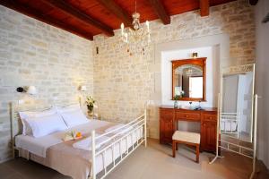 a bedroom with a bed and a vanity and a mirror at Stefanos Village Hotel in Plakias