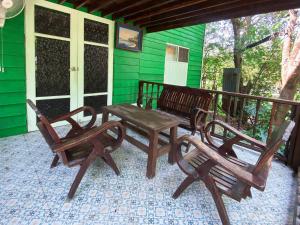 two chairs and a bench on a porch at เรือนเงินตรา in Ban Khlong Hok