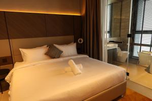 a bedroom with a white bed with a teddy bear on it at Antara Genting Cozy Studio in Genting Highlands +7 photos