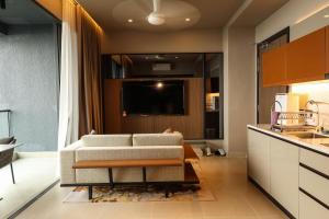 a living room with a couch and a kitchen at Antara Genting Cozy Studio in Genting Highlands