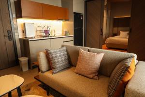 a living room with a couch and a kitchen with a bed at Antara Genting Cozy Studio in Genting Highlands