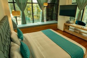 a bedroom with a bed with a television and a window at Joven's central hotel in Bangalore