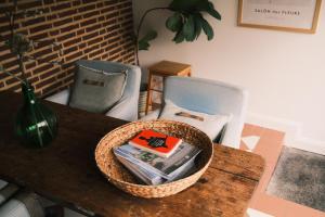 Ein Korb mit Büchern auf einem Tisch mit zwei Stühlen in der Unterkunft Vakantiewoning Guesthouse MOMO in Dilsen-Stokkem