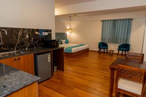 a hotel room with a bed and a kitchen at Joven's central hotel in Bangalore