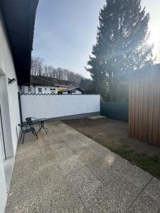 a patio with a bench next to a white wall at Loft05 in Wankham