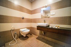 a bathroom with a toilet and a sink at Sri Saai Surguru Residency in Pondicherry +32 photos