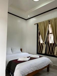 a bedroom with two beds and a window at Janh Ya Phone Guesthouse in Pakbeng