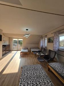 a room with three beds and a table and chairs at Cicha Dolina in Wydminy +53 photos