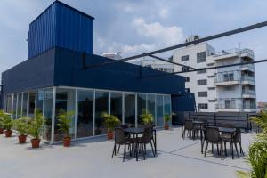 a blue building with tables and chairs in a courtyard at Joven's central hotel in Bangalore