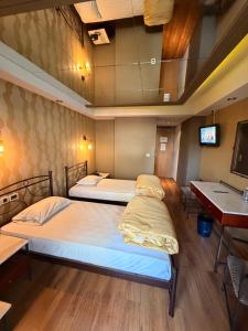 two beds in a room with a tv and a table at HOTEL PRIVE in Skaramangás +10 photos