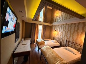 a hotel room with two beds and a flat screen tv at HOTEL PRIVE in Skaramangás