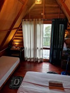 a bedroom with two beds and a large window at The Cliff Lodge Ella in Ella