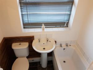 uma casa de banho com um WC, um lavatório e uma banheira em Sea Glass Cottage em Sunderland