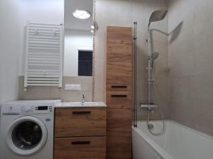 a bathroom with a washing machine and a washer at Sielawy Apartament in Poznań