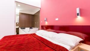 Dormitorio rojo con cama grande y espejo grande en Dream Hotel en Velika Gorica