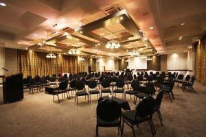 une salle de banquet avec des chaises et un podium dans une chambre dans l'établissement Hotel Osner, à East London