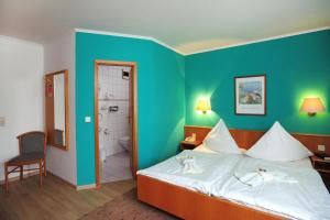 a hotel room with a bed and a bathroom at Landhotel Plauen - Gasthof Zwoschwitz in Plauen