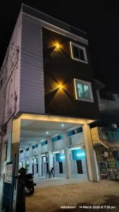a building with a motorcycle parked in front of it at Hotel Grand Arputha in Velankanni