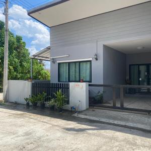 a white house with plants in front of it at Lucky Villa by Saran in Ban Khlong Chi Lat