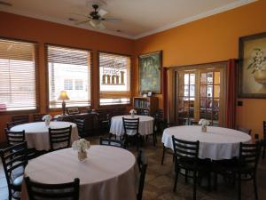 a dining room with tables and chairs with white tablecloths at Main Street Inn in Lowell +4 photos