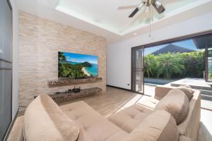 a living room with a couch and a large window at 3BR Pool Green Park Villa near Rawai Beach in Ban Saiyuan (1)