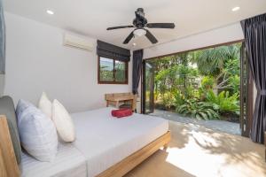 a bedroom with a bed and a ceiling fan at 3BR Pool Green Park Villa near Rawai Beach in Ban Saiyuan (1) +29 photos