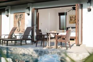 a patio with a table and chairs next to a pool at 3BR Pool Green Park Villa near Rawai Beach in Ban Saiyuan (1)