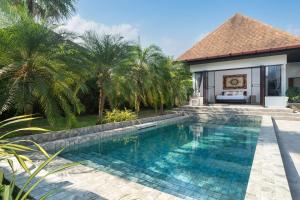 a swimming pool in front of a house with palm trees at 3BR Pool Green Park Villa near Rawai Beach in Ban Saiyuan (1)