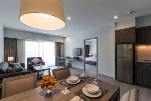 a kitchen and living room with a table and a dining room at Kantary Hotel And Serviced Apartment, Amata, Bangpakong in Ban Tamru