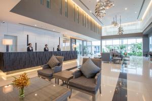 a lobby with chairs and a bar with people in the background at Kantary Hotel And Serviced Apartment, Amata, Bangpakong in Ban Tamru