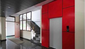 a room with a red wall and a staircase at Red carpet hotel in Kangra