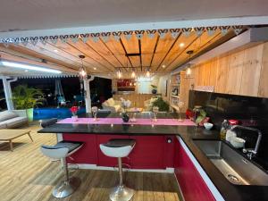 a kitchen with a bar with two stools at Le coin des romarins in Saint-André