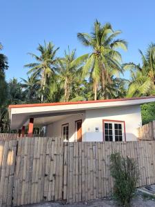 a house with palm trees behind a fence at La Paula Hostel in San Juan +20 photos