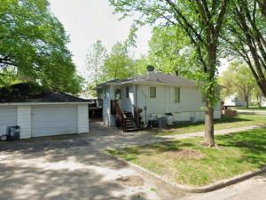 a small white house with a tree in the yard at Hot Tub 5 beds in Moorhead
