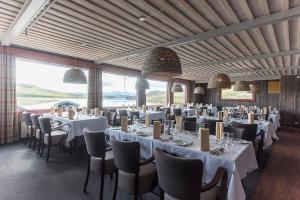 a dining room with tables and chairs and windows at Bergsjøstølen Fjellstue in Bergsjostolen +30 photos