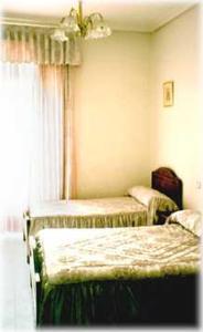 マドリードにあるオスタル リヴェラ アトーチャのベッドルーム1室(ベッド2台、窓付)
