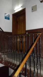 a spiral staircase with a wooden door in a building at Hostal Rivera - Atocha in Madrid