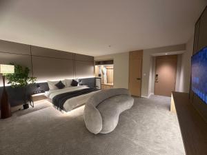 ein Schlafzimmer mit einem Bett, einer Couch und einem Fernseher in der Unterkunft Amure hotel in Ulaanbaatar