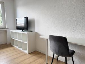 a room with a desk and a tv and a chair at 3 Zimmer Apartment mit Garten in Wuppertal +10 photos