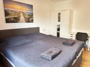 a bedroom with a bed with two towels on it at 3 Zimmer Apartment mit Garten in Wuppertal