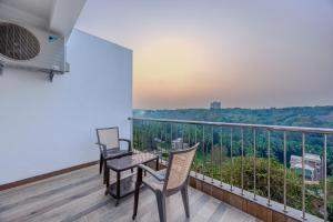 a balcony with two chairs and a table with a view at ALAYA STAYS Midpoint UMA Pet-Friendly 7 BHK Villa Pool and Entertainment in Chicalim