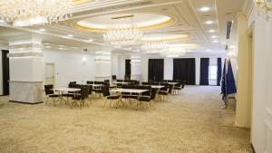 a dining room with tables and chairs and chandeliers at فندق البرج الابيض - White Tower Hotel in Ōlmush