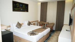 a hotel room with a bed and a television at فندق البرج الابيض - White Tower Hotel in Ōlmush +16 photos
