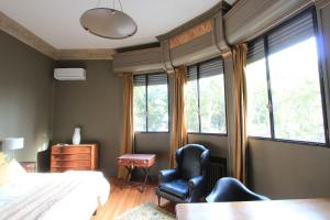a bedroom with a bed and two chairs and a desk at -Casa Haydée- in Paysandú