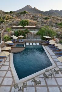 a pool with chairs and umbrellas at a resort at Elounda Orama by GHH in Elounda +40 photos