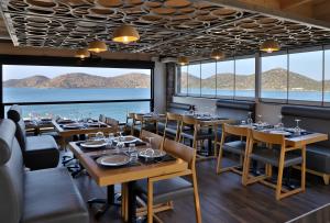 a restaurant with tables and chairs and a view of the water at Elounda Orama by GHH in Elounda