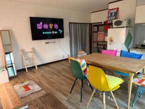 a living room with a table and chairs and a tv at パノラマスター白子-Panoramastars Shirako-星降る夜の貸切ステイ in Shirako