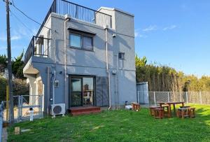 a house with two picnic tables in front of it at パノラマスター白子-Panoramastars Shirako-星降る夜の貸切ステイ in Shirako