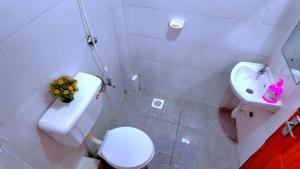a white bathroom with a toilet and a sink at The Loft & Found in Nairobi