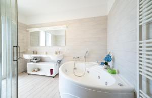 a white bathroom with a tub and a sink at Avola Sun & Sea Sicily in Avola +40 photos